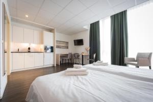 贝尔普Los Lorentes Aparthotel Bern Airport的酒店客房带两张床和厨房