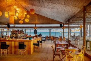 YumruAlaçatı Beach Resort的餐厅设有酒吧和桌椅