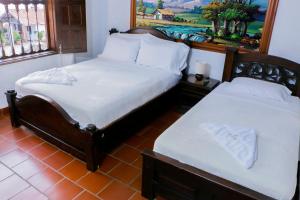 巴里查拉芬卡艾丽西亚别墅度假屋的卧室设有两张单人床,墙上挂着一幅画