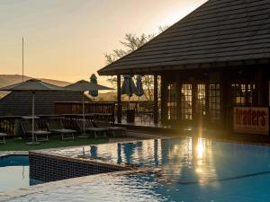 雾观哈斯美景小屋旅馆的一个带游泳池、桌子和遮阳伞的度假村