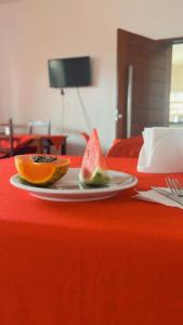 马塞约Pousada Girassol的红桌上两个水果片的盘子