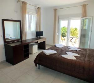 阿斯特里斯Thasos Seaside Serenity - Seaview & Garden Nests的一间卧室配有一张床和一张带镜子的书桌