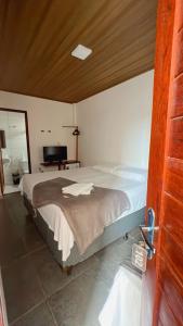 马塞约Pousada Girassol的一间卧室配有一张大床和电视
