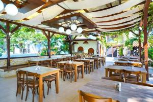 佩弗卡里Thassos ESPERIA HOTEL的一间设有木桌和椅子的餐厅,以及