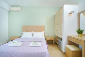佩弗卡里Thassos ESPERIA HOTEL的一间卧室配有一张紫色床和两条毛巾