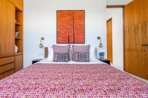 坎古Mandala Residences的一间卧室配有一张大床和彩色床罩
