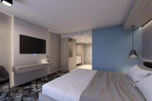 代托纳海滩海洋微风俱乐部酒店的卧室配有一张床,墙上配有电视。