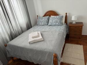 奥德米拉Cabo Sardão Guest House的一间卧室配有一张床,上面有两条毛巾