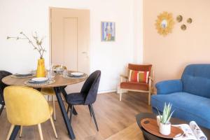 斯特拉斯堡La Robertsau, Lumineux, Paisible的客厅配有桌子和蓝色沙发
