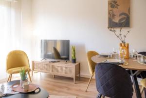 斯特拉斯堡La Robertsau, Lumineux, Paisible的客厅配有桌子和电视