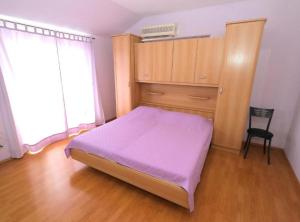 赫瓦尔Apartments Trogrlić的一间卧室配有一张床、一个橱柜和一把椅子