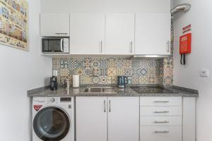 加亚新城Trendy comfort in Vila Nova de Gaia的厨房配有洗衣机和水槽