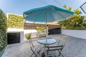 加亚新城Trendy comfort in Vila Nova de Gaia的庭院内桌椅和遮阳伞