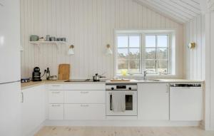 维斯特索马肯Beautiful Home In Aakirkeby With Kitchen的厨房配有白色橱柜、水槽和窗户。