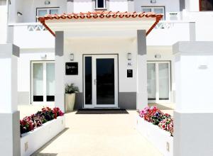 米尔芳提斯城River Inn - Duna Parque Group的白色的房子,有门和鲜花