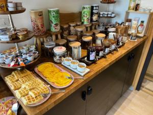 Sains-du-NordLe Domaine des Fagnes的餐桌上的自助食品,包括早餐食品