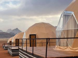 瓦迪拉姆Shaheen Camp Wadi rum的沙漠中一排圆顶帐篷