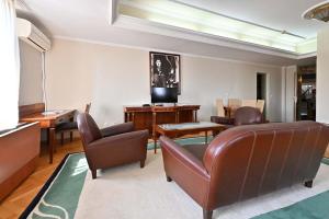诺维萨德Sole Mio Wellness & SPA的客厅配有皮椅和电视