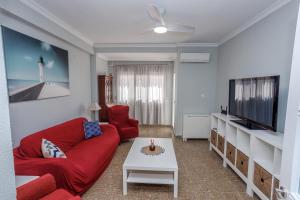 加的斯Apartamento Playa Santa María del Mar的客厅配有红色沙发和电视