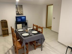 马德里Apartamento completo para 8 personas a 5 minutos del aeropuerto e IFEMA的一间带桌椅和电视的用餐室