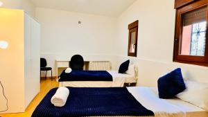 马德里Apartamento completo para 8 personas a 5 minutos del aeropuerto e IFEMA的酒店客房设有两张床和窗户。