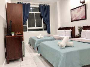 胡志明市Saigon Cozy2 Hotel的酒店客房设有两张床和窗户。