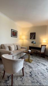 安曼Amman Paradise Hotel的客厅配有沙发和桌子