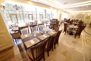 安曼Amman Paradise Hotel的一间在房间内配有桌椅的餐厅