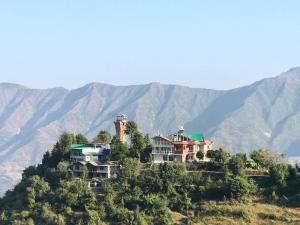穆索里The Himalaya Retreat Resort, Experience Nature in the Lap of Himalayas的山丘上以山为背景的房子