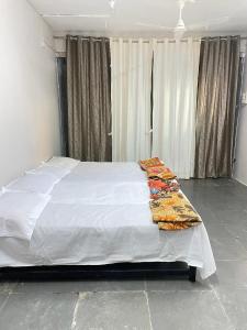 TuljapurTuljai Homestay的一间卧室配有一张带白色床单的大床