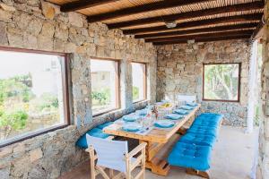 米克诺斯城Dreamy Boho 5bed Villa with Pool and Ocean View的一间带木桌和椅子的用餐室