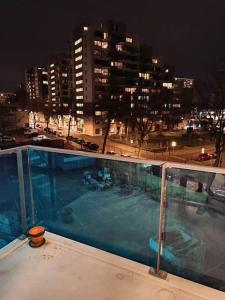 海牙La Maison Bleue - La Haye的一座游泳池,在晚上在一座建筑的顶部