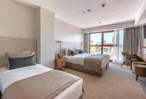 马德普拉塔HOTEL KONKE MAR DEL PLATA的酒店客房配有两张床和一张书桌