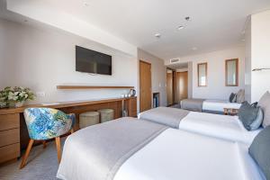 马德普拉塔HOTEL KONKE MAR DEL PLATA的酒店客房设有两张床和电视。