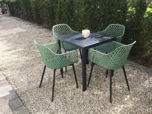 奥德纳尔德Gezellige Studio met terras的一张带三把椅子的黑桌子和一杯