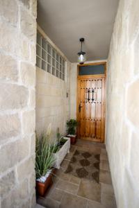 CastelserásEl Canton De Carlos的走廊上设有木门和盆栽植物