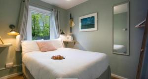 圣艾夫斯Painters Cottage 2-Bed Chalet nr St Ives & Hayle的一间卧室,配有一张带一盘食物的床