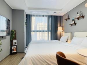 首尔INN-The City MyeongDong的卧室配有一张白色的大床和一张桌子
