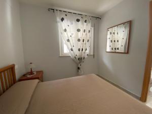 波利科罗Appartamento in Villa a Policoro的一间卧室设有一张床和一个窗口