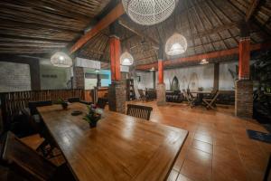 乌鲁瓦图Olo Surf Nature的一间带木桌和椅子的用餐室