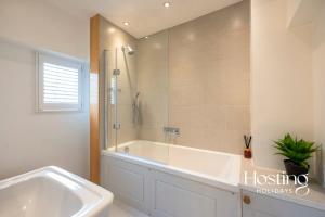 亨利昂泰晤士Spacious Luxury Cottage With Roof Terrace Close To The River Thames的白色的浴室设有浴缸和淋浴。