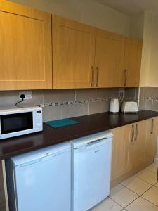 利物浦Lovely 2-Bed House in Liverpool的厨房配有冰箱和微波炉。