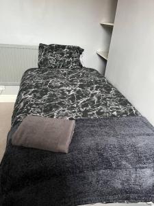 利物浦Lovely 2-Bed House in Liverpool的一间卧室配有一张带黑白毯子的床