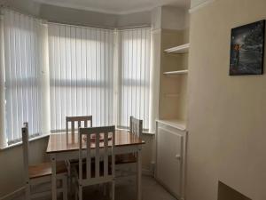 利物浦Lovely 2-Bed House in Liverpool的一间带木桌和椅子的用餐室