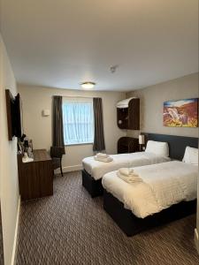 斯特灵Highland Gate, Stirling by Marston's Inns的酒店客房配有两张床和一张书桌