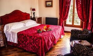 威尼斯拉卡尔西纳酒店的一间卧室配有一张大床和红色的床罩