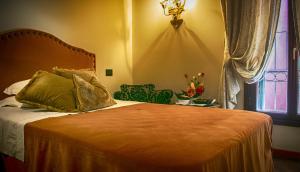 威尼斯拉卡尔西纳酒店的一间卧室设有一张床、一个窗口和一把椅子