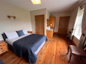 罗斯莱尔St Martin's, Rosslare Harbour Guest Accommodation的一间卧室配有一张床,铺有木地板