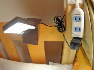 京都雅顺旅馆的吹风机与一张带灯的床铺相连