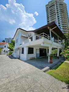 丹绒武雅Little Heaven by Sky Hive, A Beach Front Bungalow的带阳台的白色房屋和高高的建筑